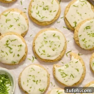 Key lime cookies with lime glaze and zest on surface.