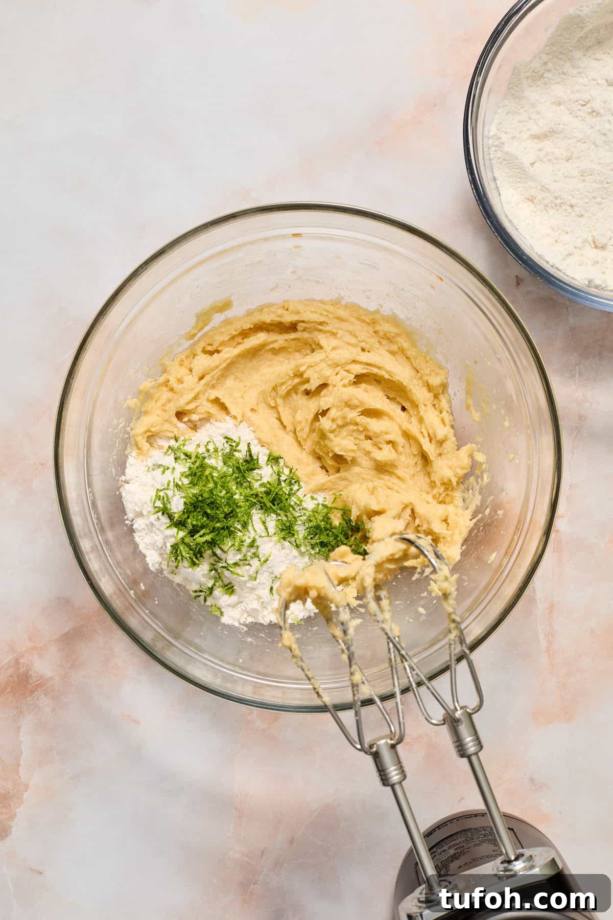 Flour and key lime zest added to mixing bowl with wet ingredients.