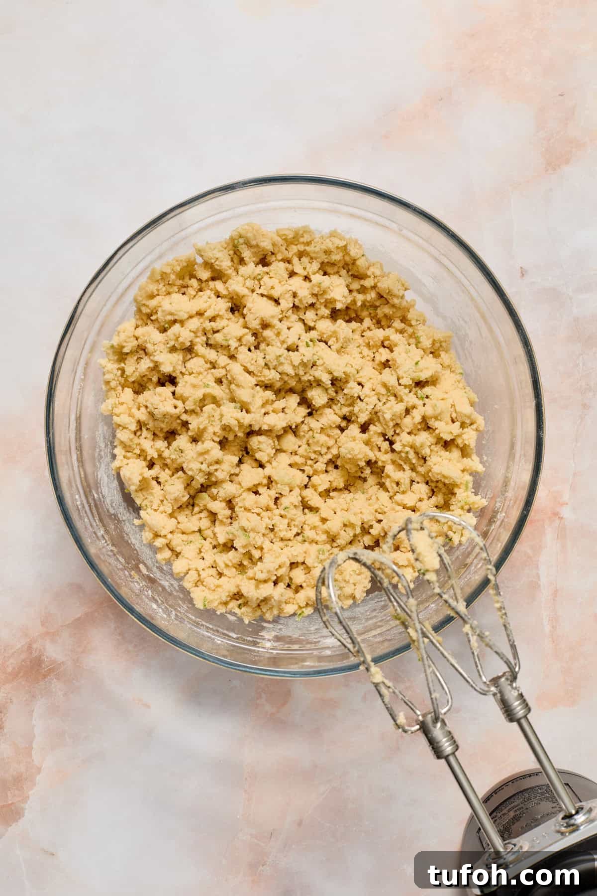 Key lime cookie dough in glass bowl before pulling together.
