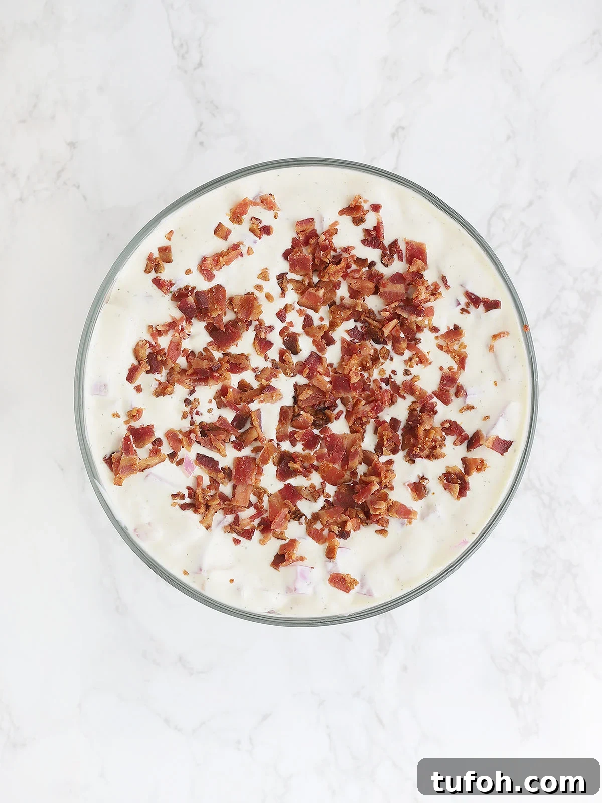 top of cornbread salad covered in ranch dressing and chopped bacon
