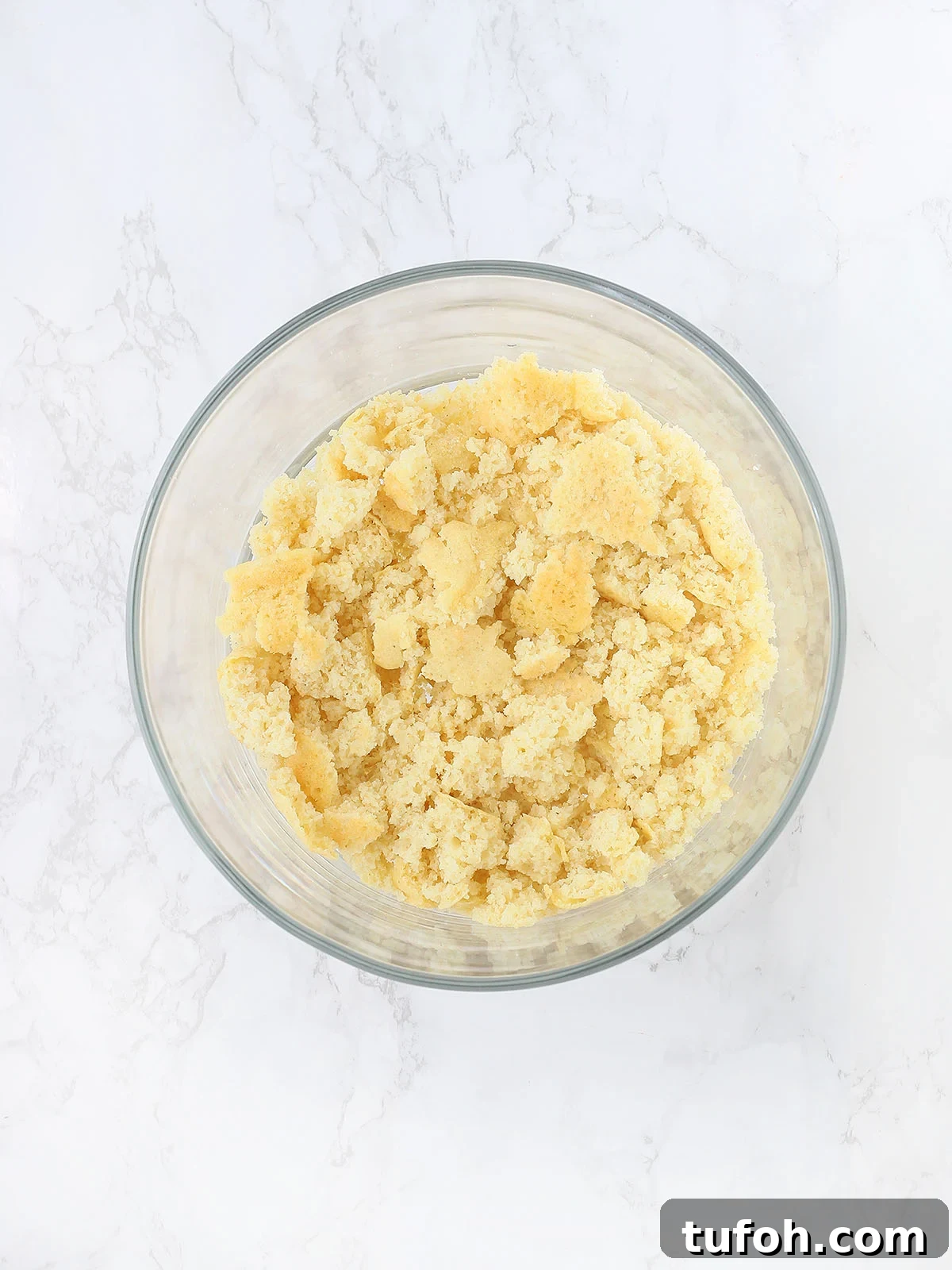 crumbled cornbread in the bottom of a glass trifle bowl