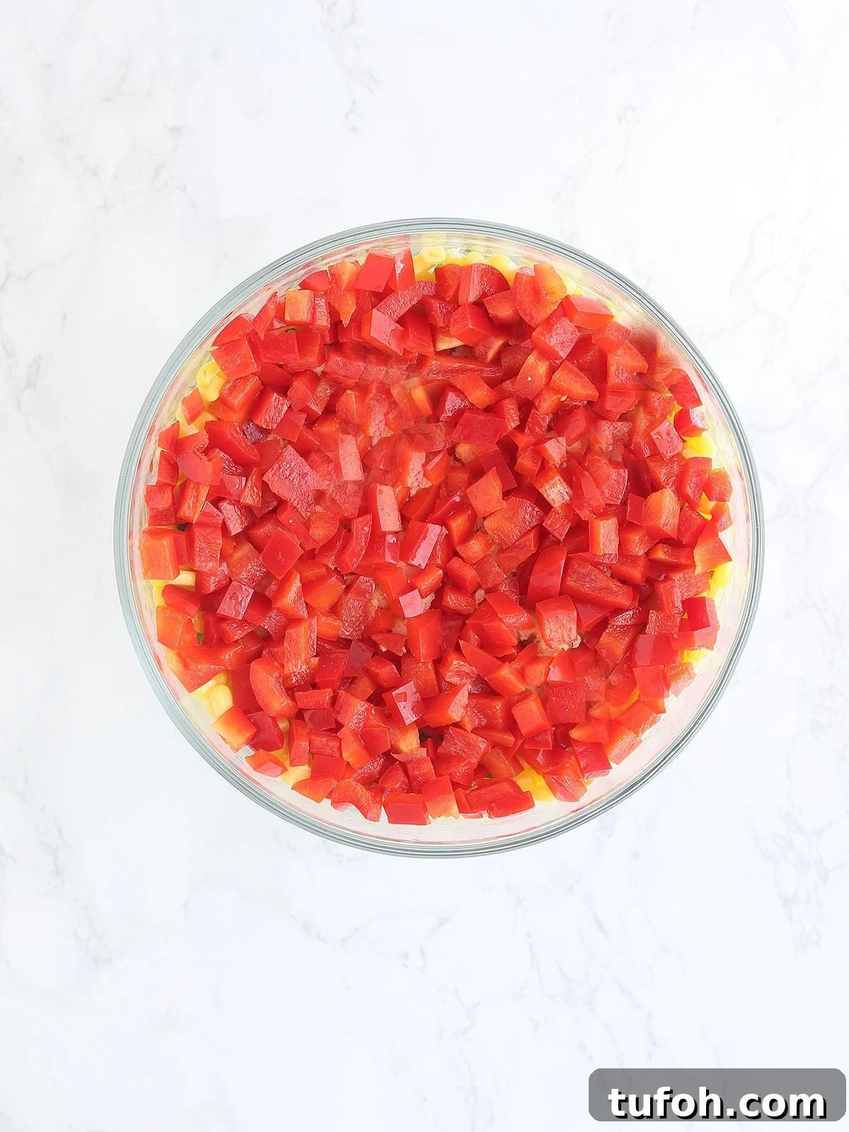 cornbread salad topped with diced red bell peppers