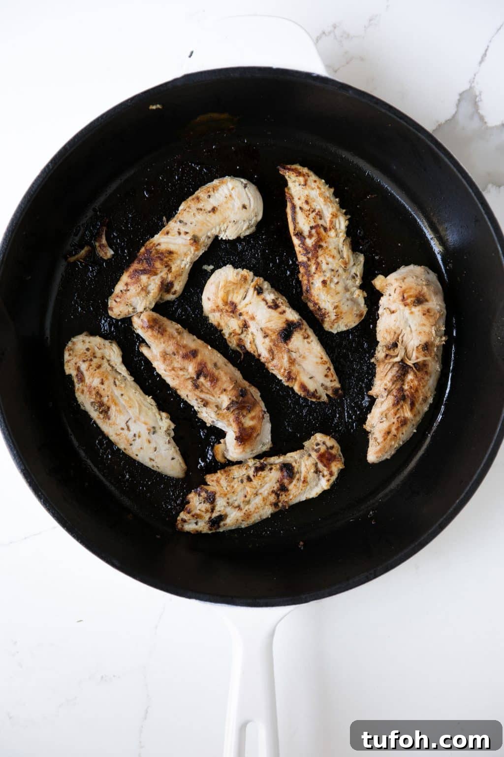 Fully cooked yogurt marinated chicken in a cast iron skillet