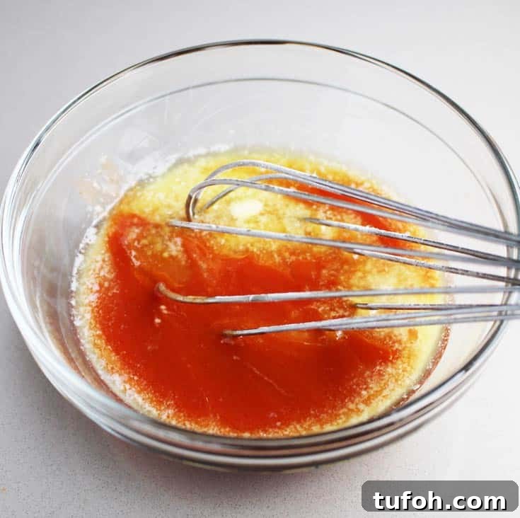 Buffalo Chicken Burgers with Tangy Blue Cheese Slaw 4 Hot sauce being whisked with butter for Buffalo chicken breast burgers