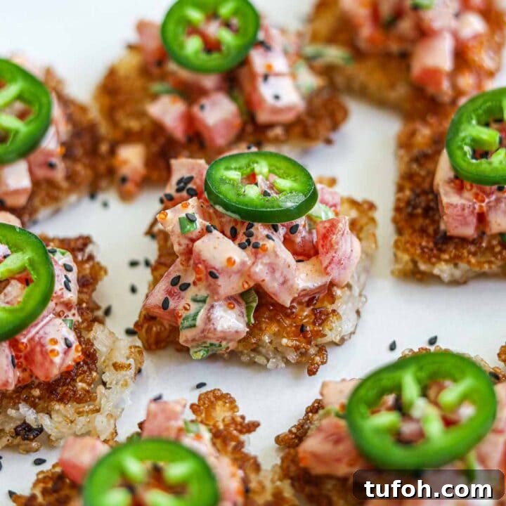 Spicy tuna with crispy rice topped with jalapeño on a platter.