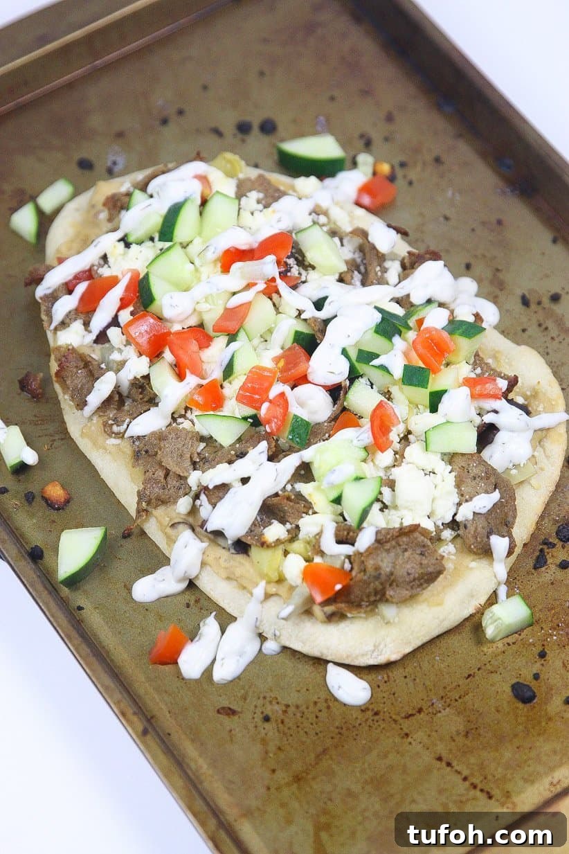 Assembled Greek pizza before baking