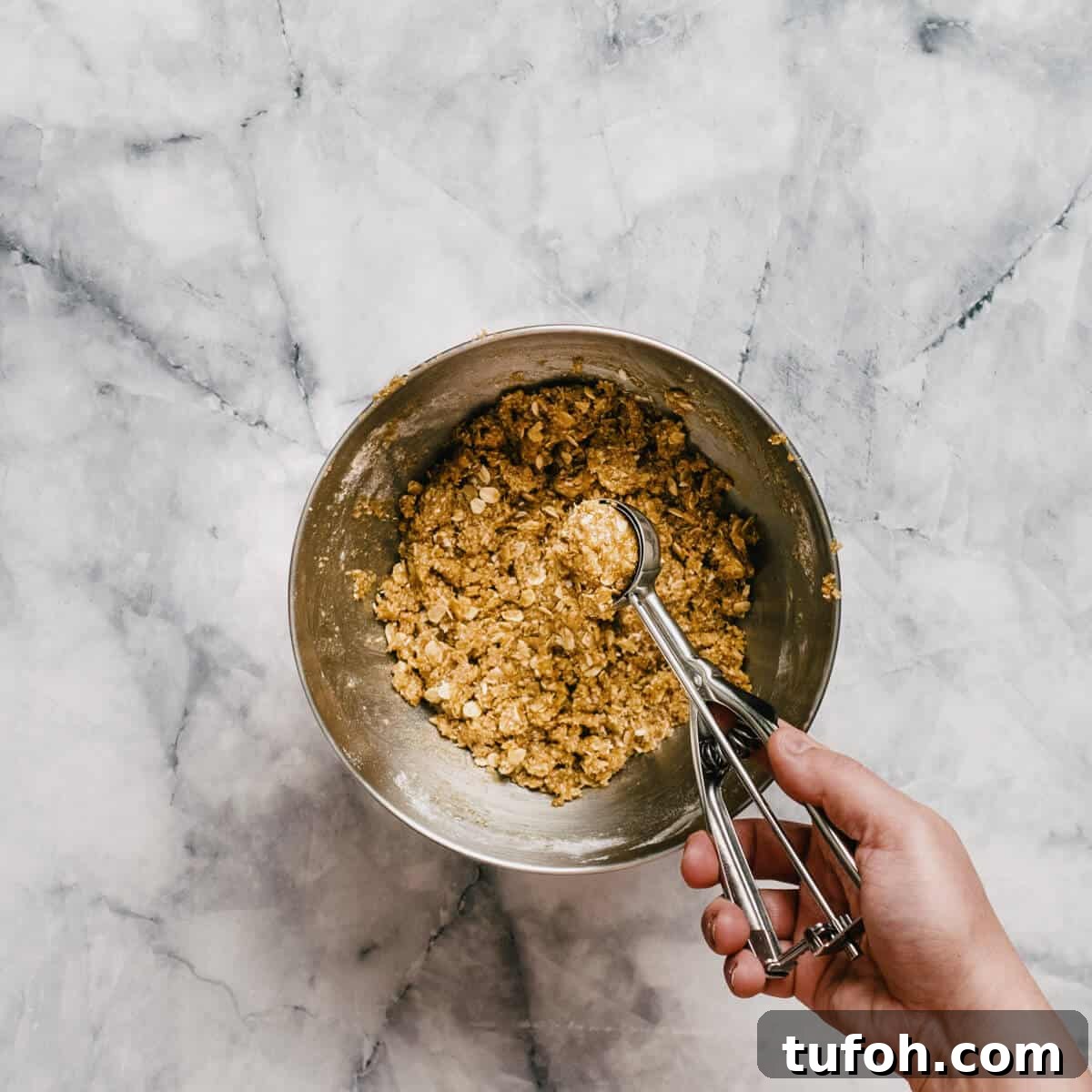 using a cookie scoop to portion out cookies.