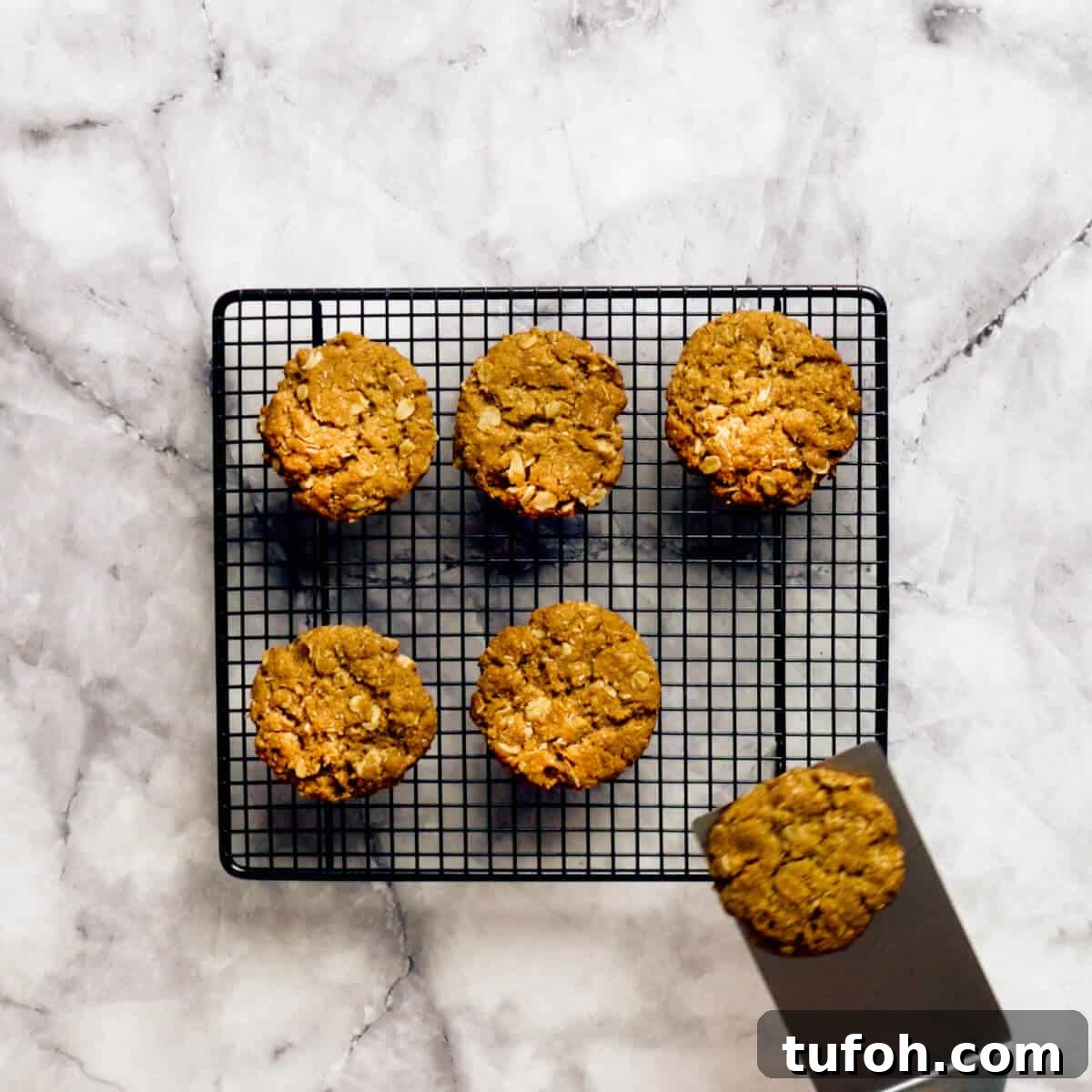 placing Anzac biscuits on a wire rack to cool.