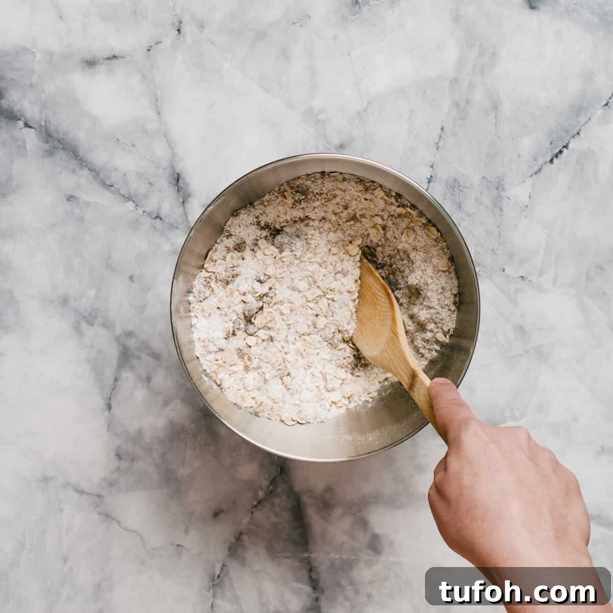 combining dry ingredients to make Anzac biscuits.