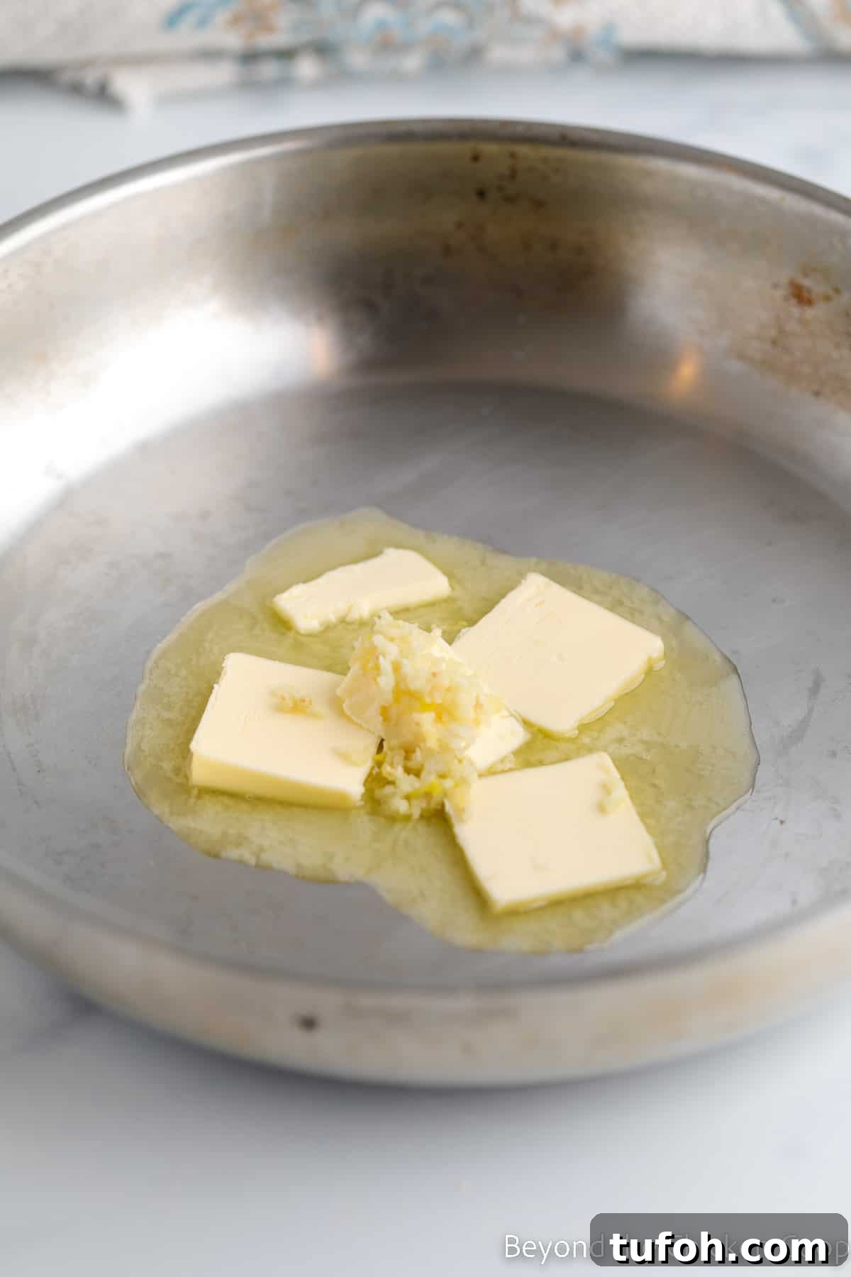 Butter melting in a pan with garlic.