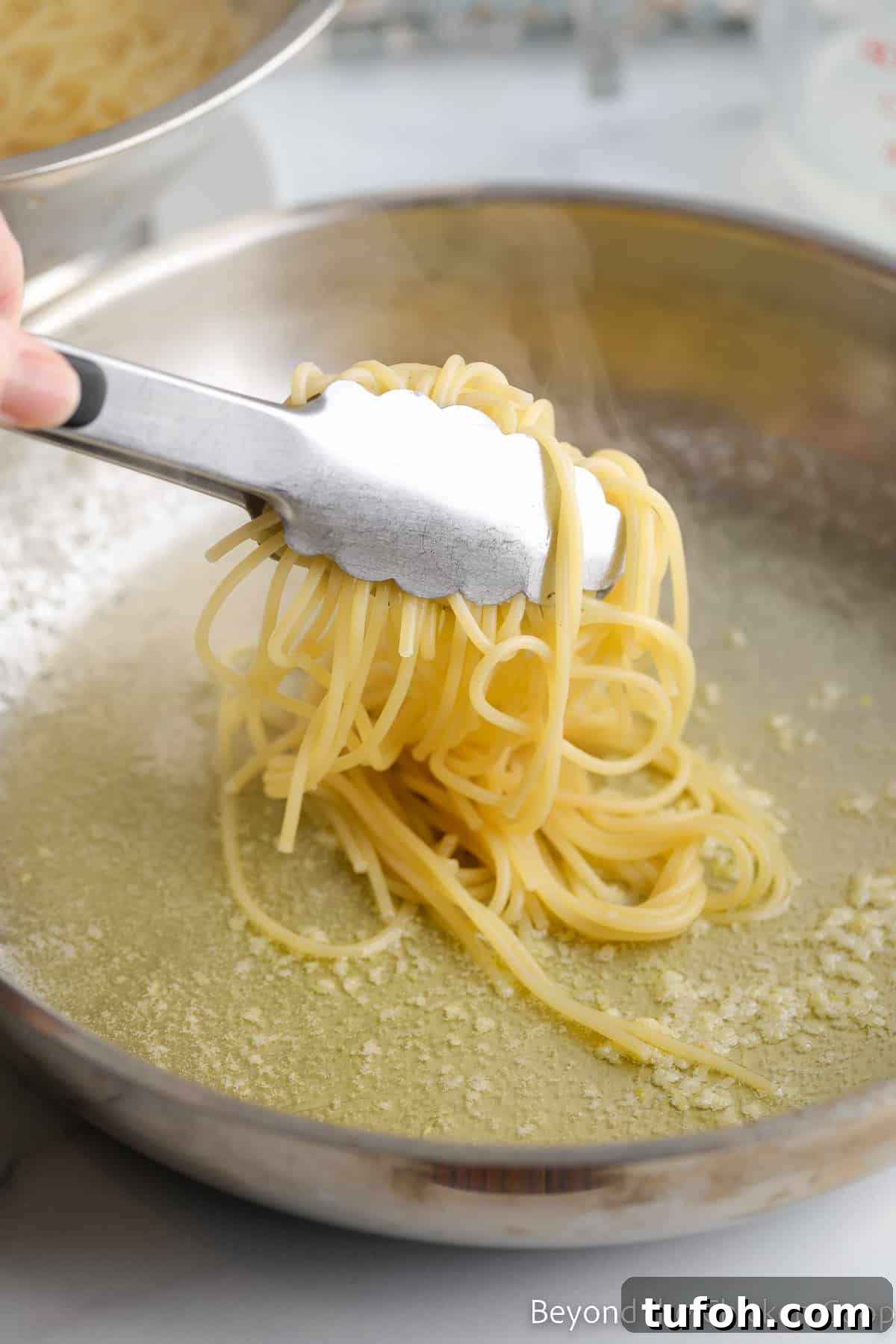 Adding spagetti noodles to a pan with butter.