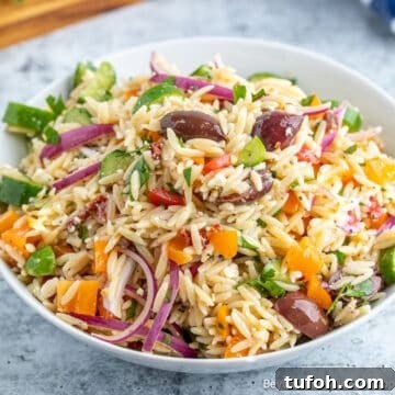 An orzo pasta salad with onions, olives and peppers.
