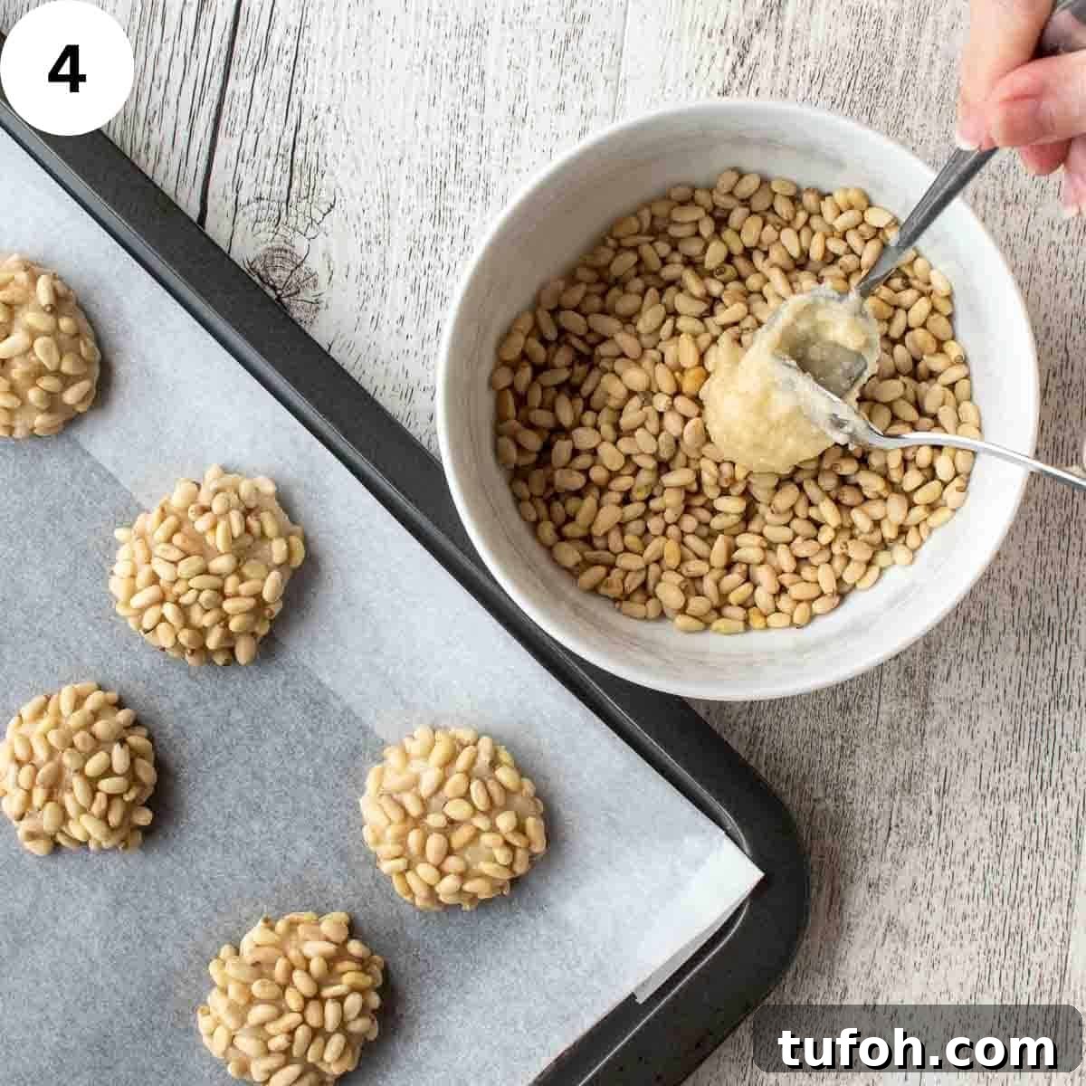 Pignoli Cookies: Classic Italian Almond Macaroon Recipe 7 Soft batter being spooned into a bowl of pine nuts.