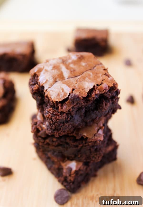These homemade brownies are classic - chewy, fudgy, and made with chocolate chips. You will love these brownies with dozens of rave reviews! A stack of chewy brownies.