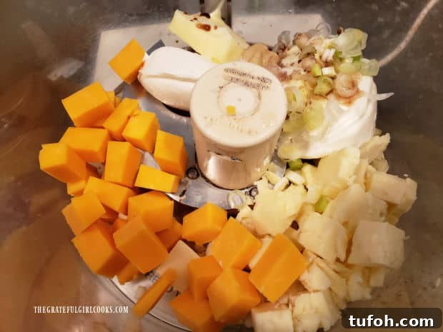 Ingredients for the cheddar jack cheese spread are placed into a food processor.