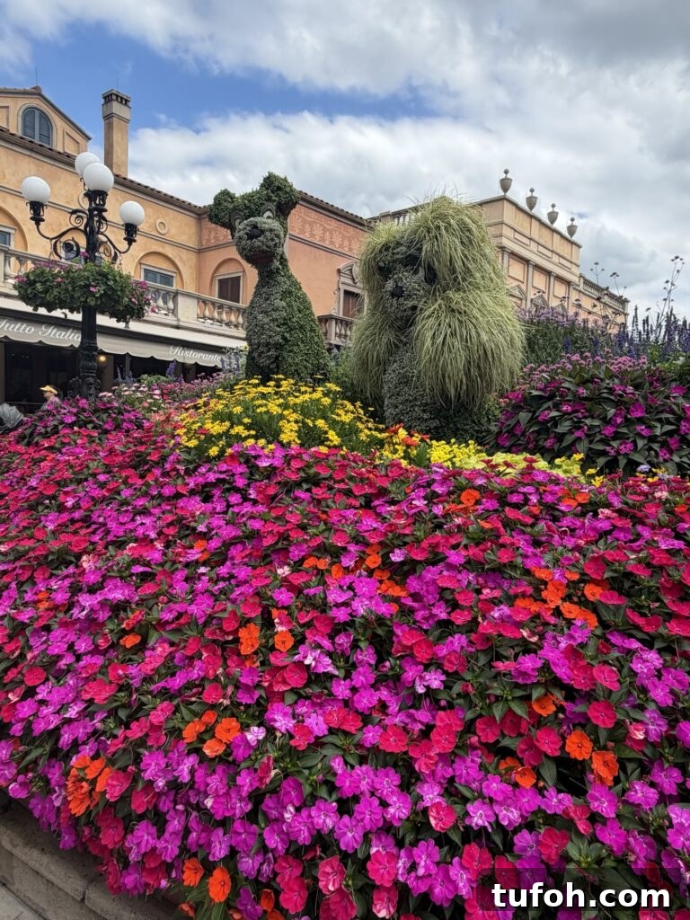 Flowers of different colors surrounding hedge sculptures of Lady and the Tramp