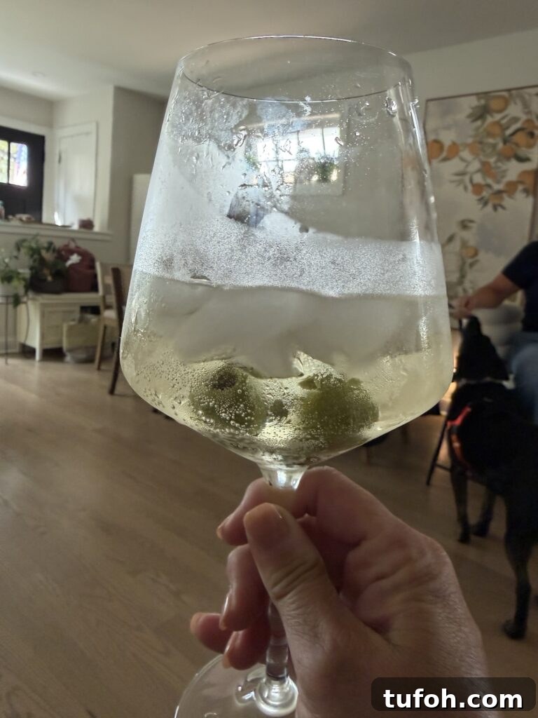 A close up of a partially drunk glass of Italicus Spritz with olives