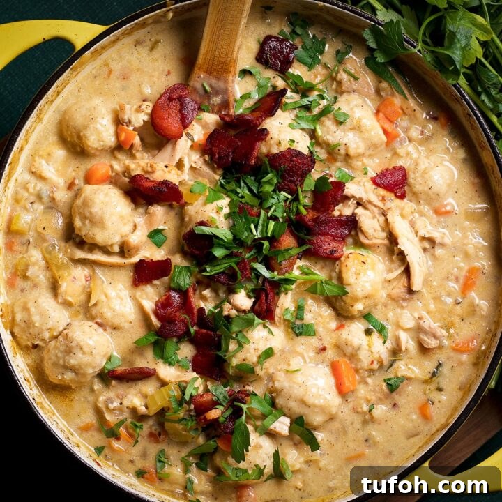 A pan filled with chicken and wild rice soup topped with crispy bacon and chopped parsley, ready to serve.