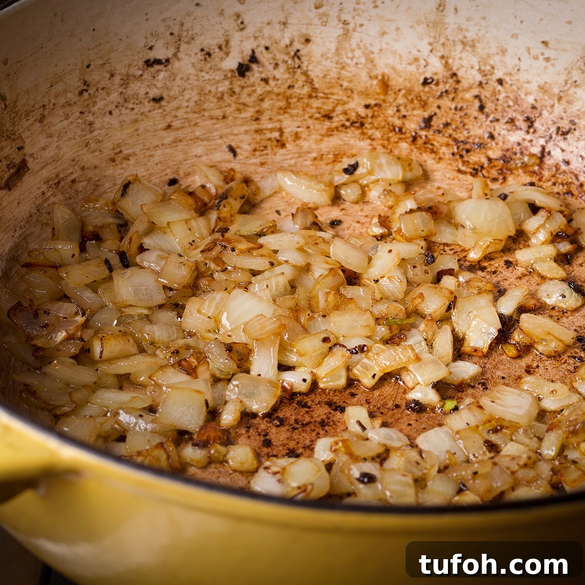 Creamy Mushroom Chicken with Parmesan Rice Bowl 7 Chopped onions cooking in some oil in a saucepan.