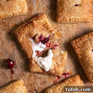 Freshly baked cherry hand pies, with one pie broken open to show filling