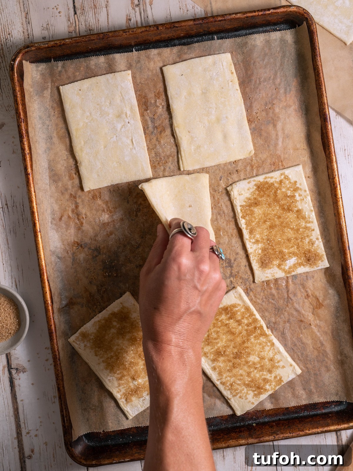 Flipping puff pastry over to make a sugary bottom crust