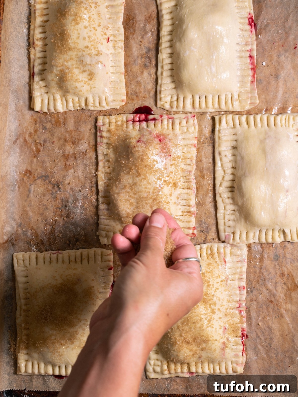 Sprinkling coarse sugar on top of hand pies