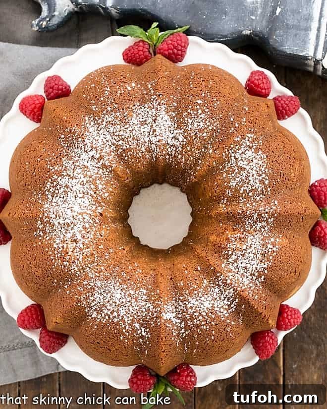 Moist White Chocolate Bundt Cake Recipe with Vanilla Glaze 2 Overhead view of white chocolate pound cake on a white cake stand.