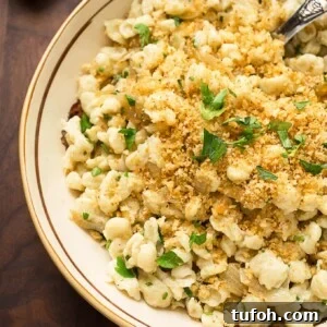 spaetzle in an invory serving bowl garnished with bread crumbs and parsely