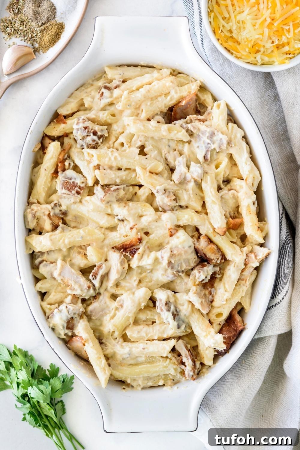 A casserole dish with the pasta chicken alfredo mixture in it.