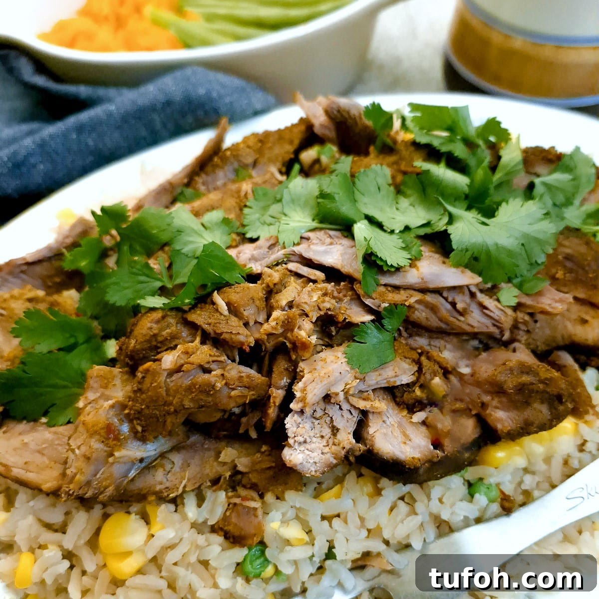 Slow-Cooked Curried Leg of Lamb in Foil for Tender Flavor 2 Close up of slices of curried slow cooked lamb on a bed of rice and peas.