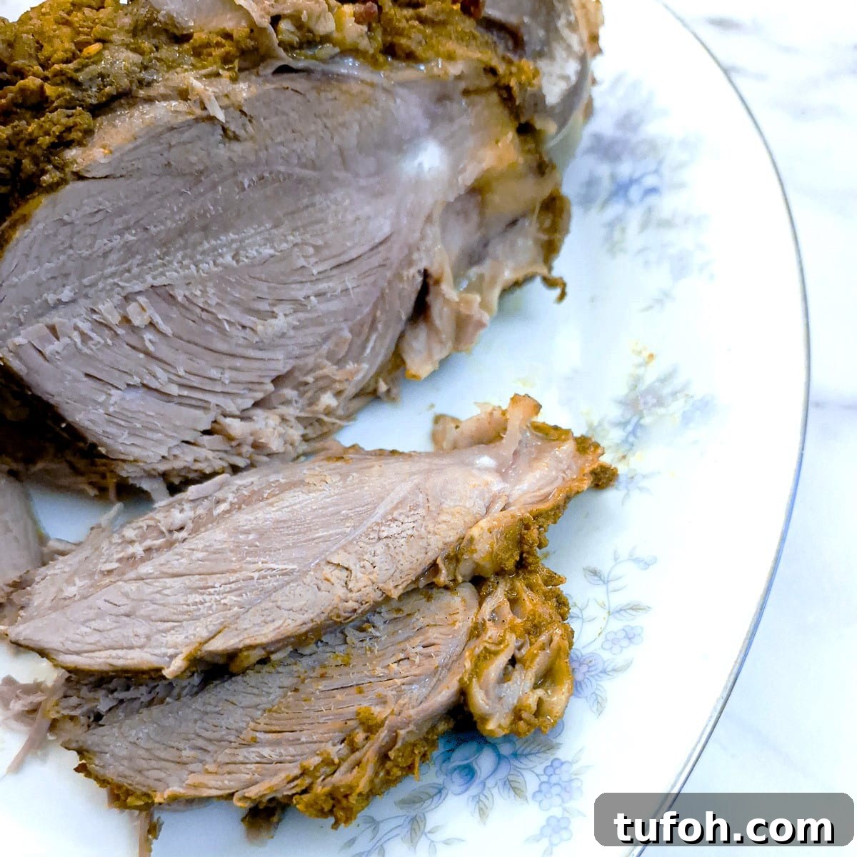 Slow-Cooked Curried Leg of Lamb in Foil for Tender Flavor 3 Slices of slow-cooked curried leg of lamb on a serving plate.