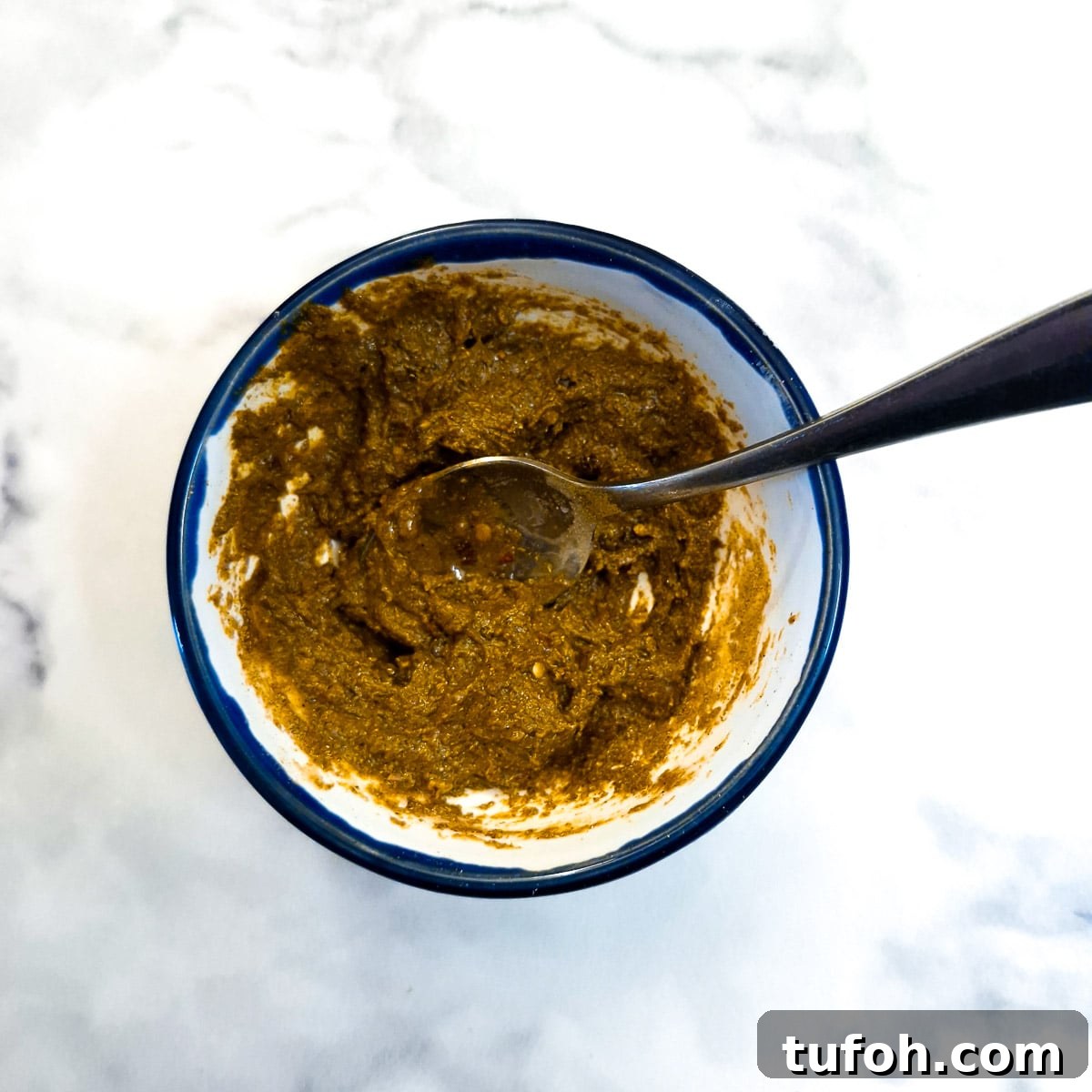 Slow-Cooked Curried Leg of Lamb in Foil for Tender Flavor 5 Fruit chutney and spices combined in a small bowl.