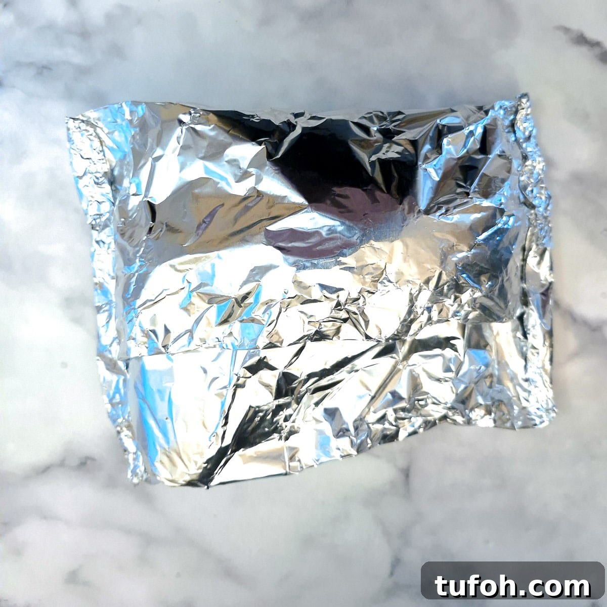 Slow-Cooked Curried Leg of Lamb in Foil for Tender Flavor 8 A tin foil-wrapped leg of lamb.