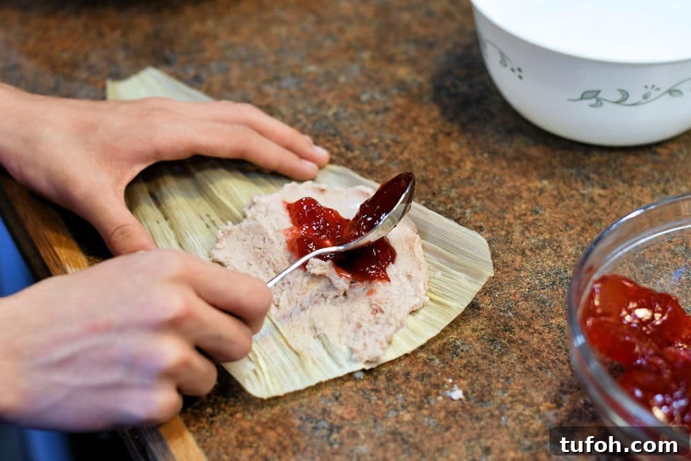 Raspberry Sweet Tamales Recipe: Decadent Mexican Dessert 6 24Bite: spreading raspberry filling on top of masa dough for sweet dessert tamal