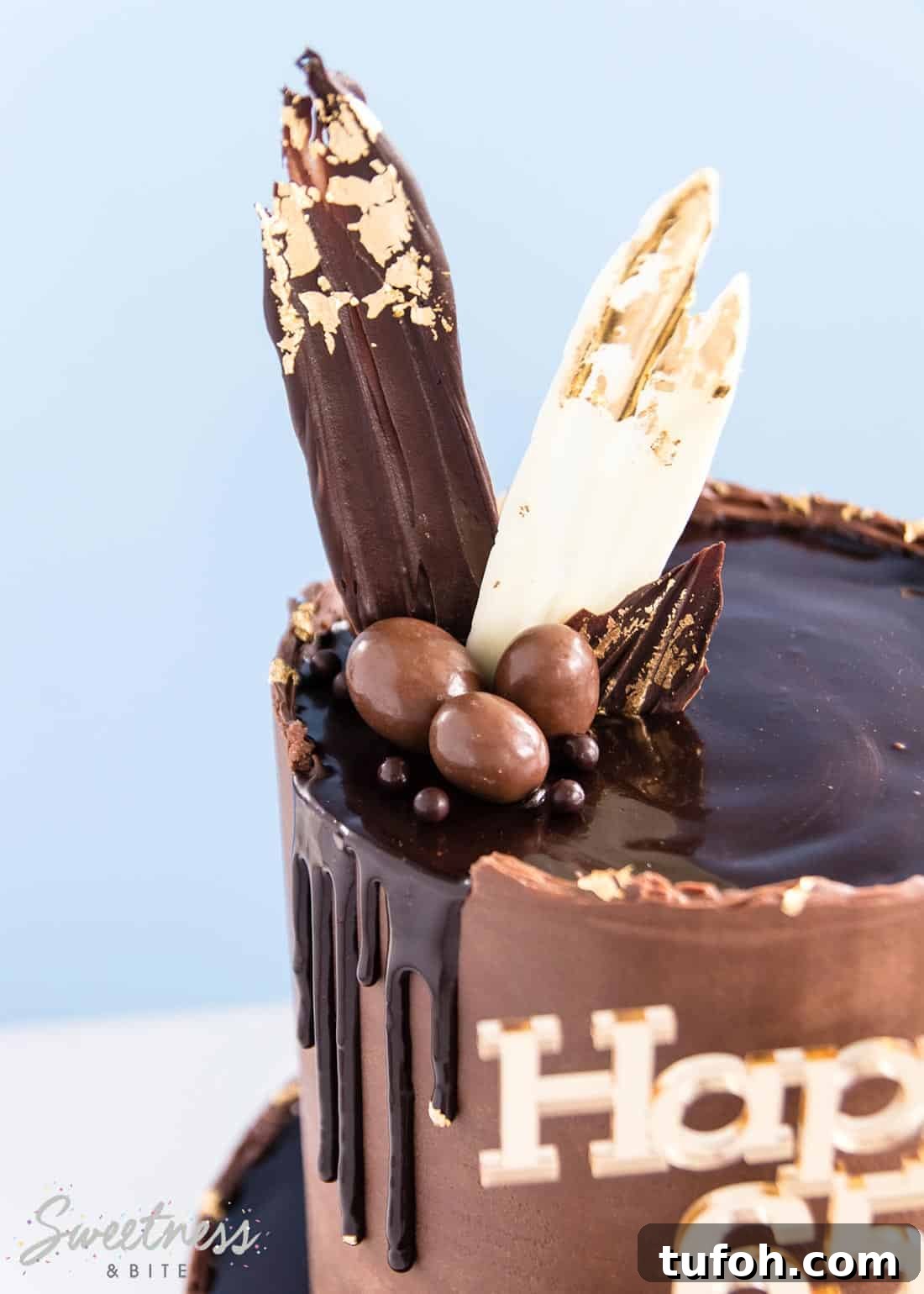 How to Make a Rough-Edge Ganache Drip Cake: Step-by-Step Tutorial 5 Close up of the shiny ganache drip and chocolates on the top of the two tier cake.