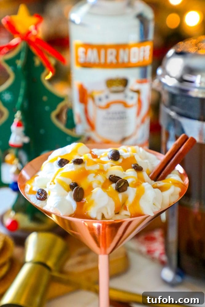 brass martini glass with cream, espresso beans, and cinnamon stick sticking out