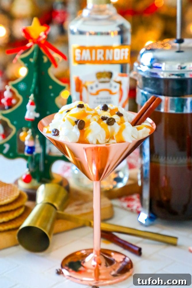 brass martini glass with cream, espresso beans, and cinnamon stick sticking out