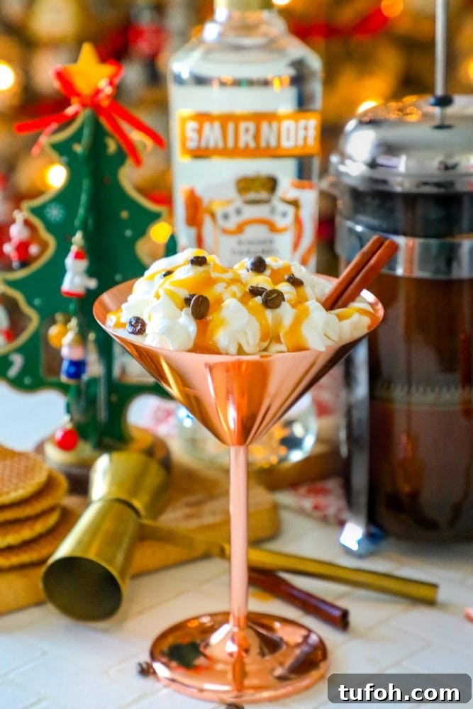 brass martini glass with cream, espresso beans, and cinnamon stick sticking out