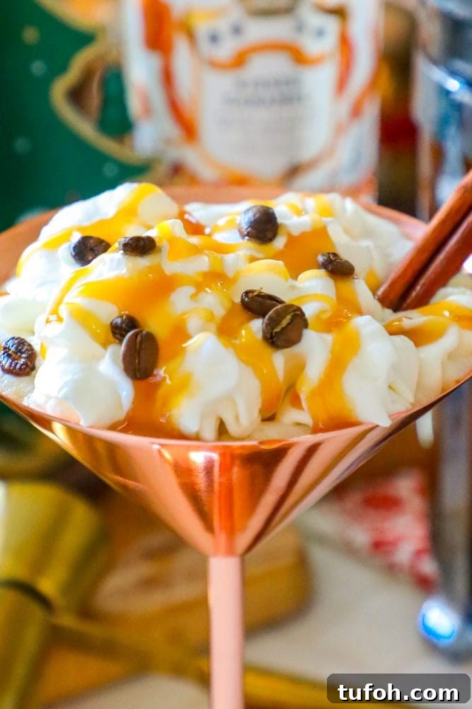 brass martini glass with cream, espresso beans, and cinnamon stick sticking out