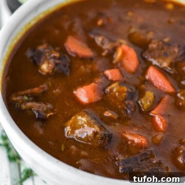 Guinness beef stew in white bowl.