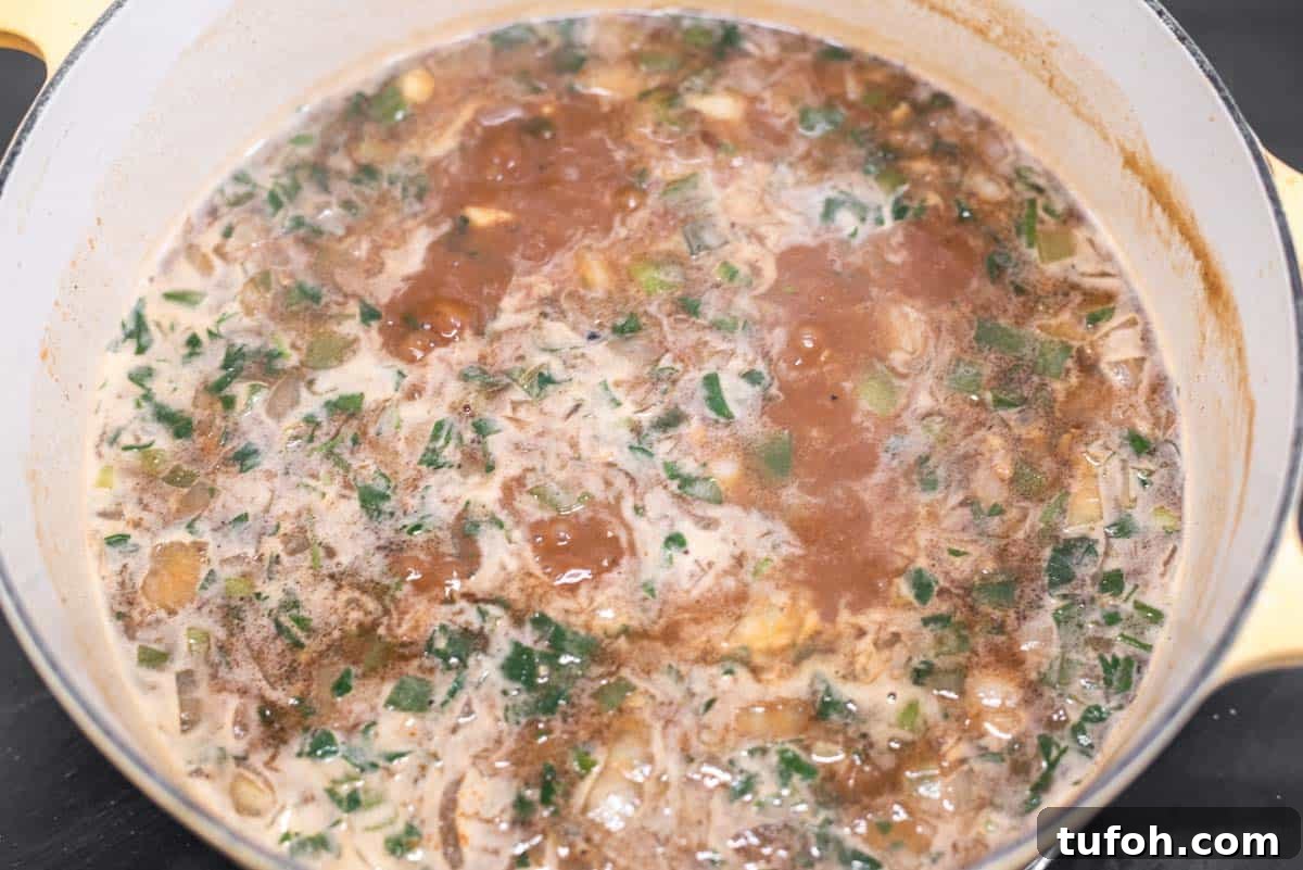 Bringing chicken broth to boil with other ingredients in Dutch oven.