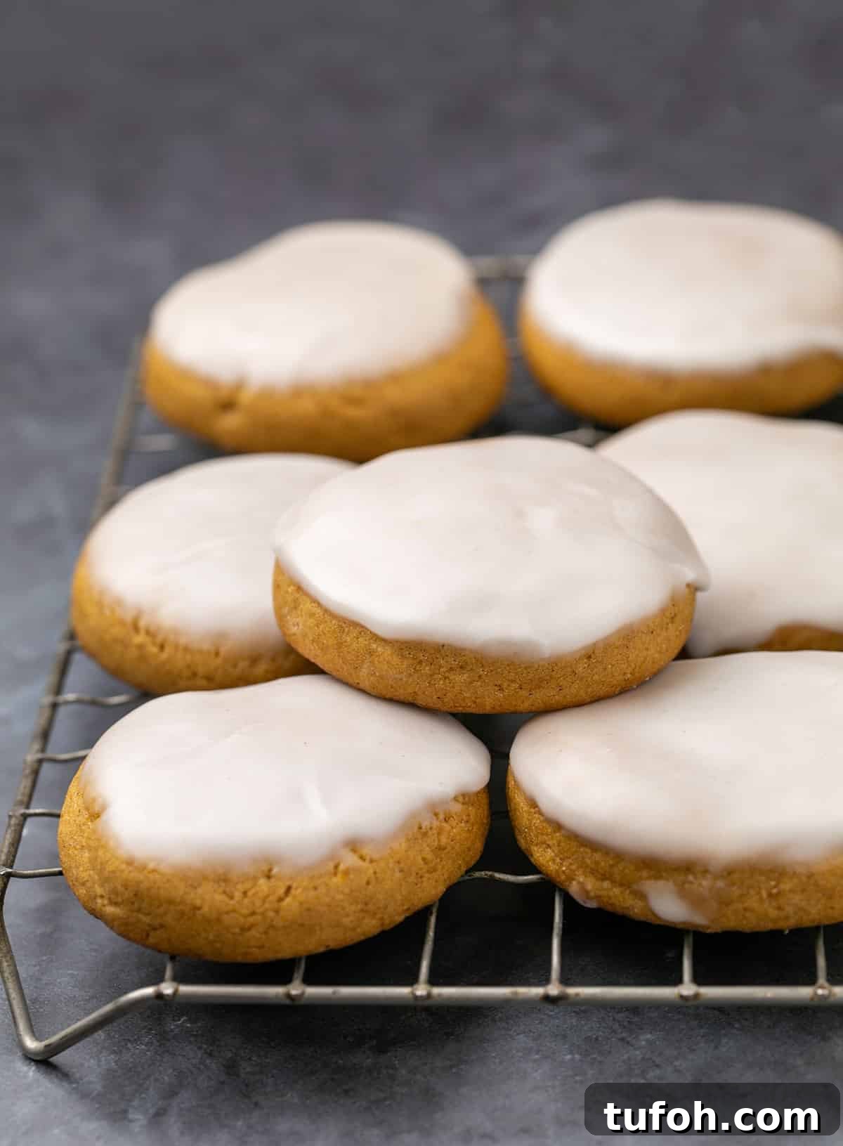 Gluten-Free Pumpkin Cookie Recipe: Soft, Chewy Fall Treat 2 Stack of pumpkin cookies with white icing on wire rack.