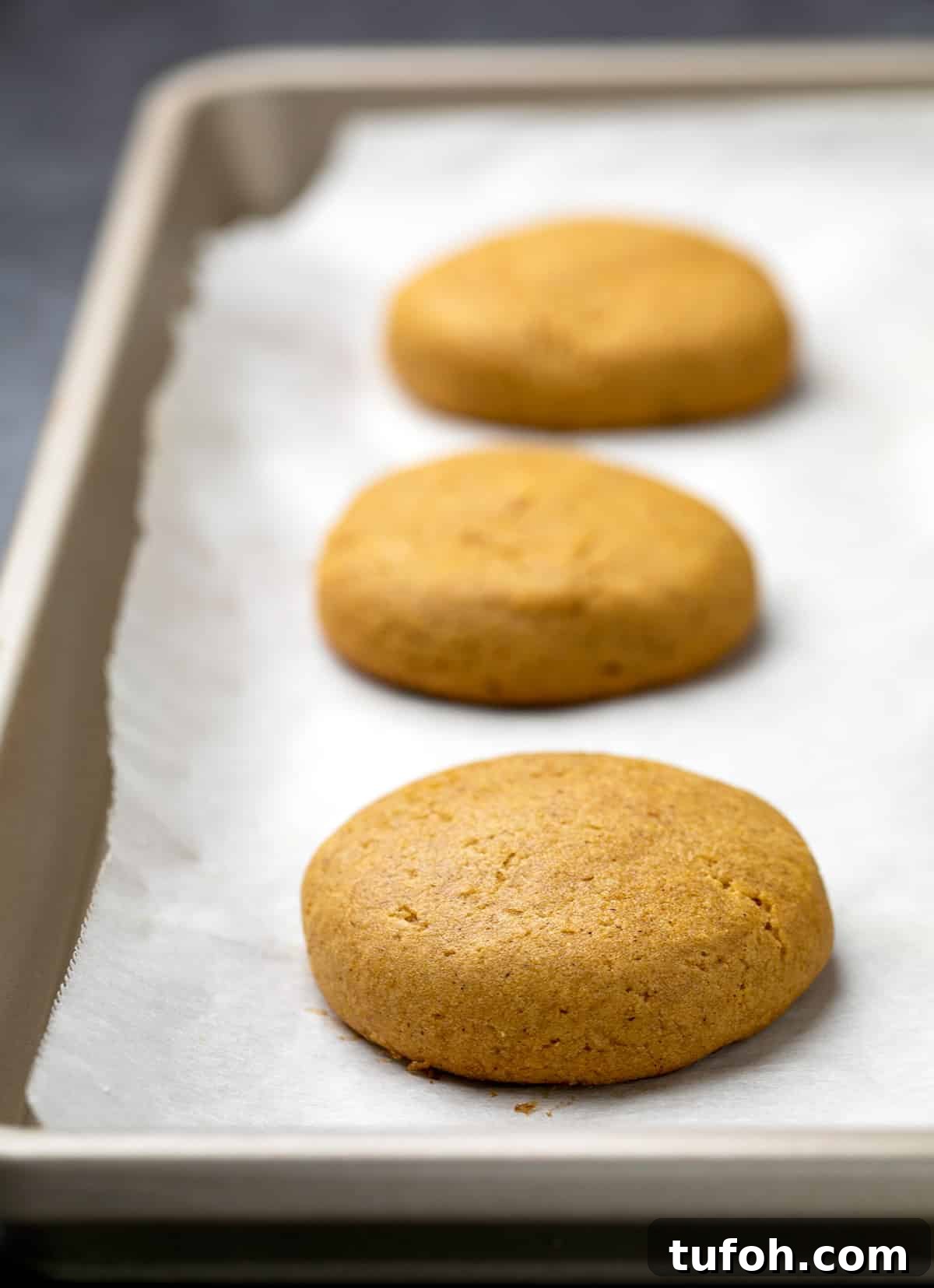 Gluten-Free Pumpkin Cookie Recipe: Soft, Chewy Fall Treat 3 3 baked pumpkin cookies on white paper on tray.