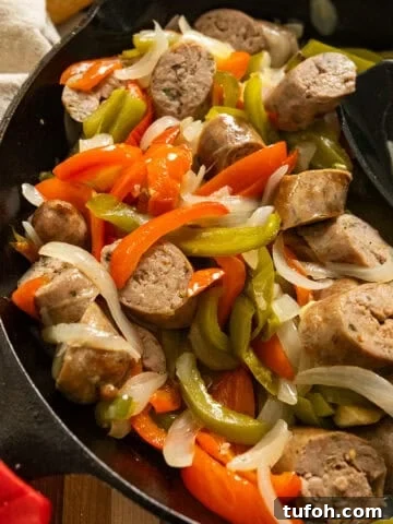 Grilled sausage and peppers in a cast iron pan.