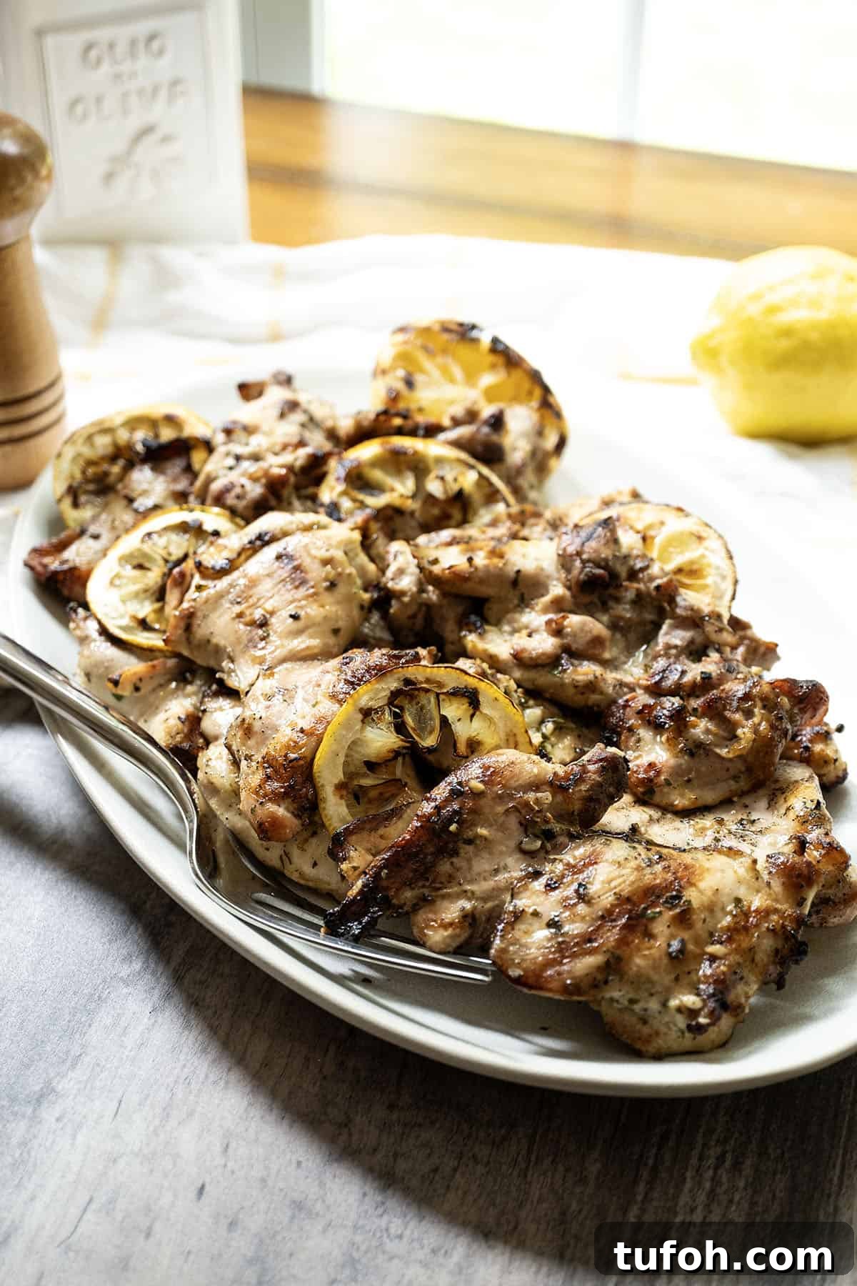 Crispy Grilled Lemon-Pepper Chicken Thighs with Zesty Marinade 8 grilled lemon pepper chicken thighs served on a plate