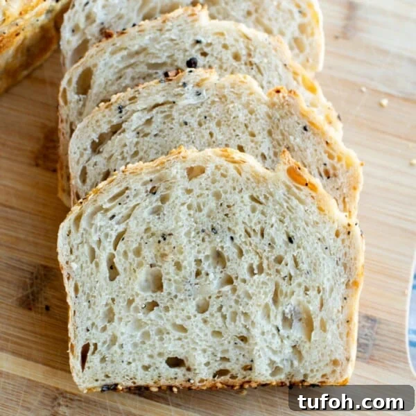 Asiago Sourdough Bagel Loaf Recipe: Chewy Crust, Tangy Interior 12 Slices of sourdough bagel bread on a cutting board.