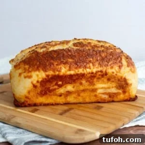Sourdough asiago bagel bread on a cutting board.