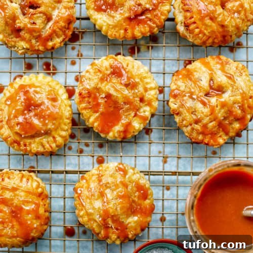 Air fryer apple hand pies on a rack with caramel