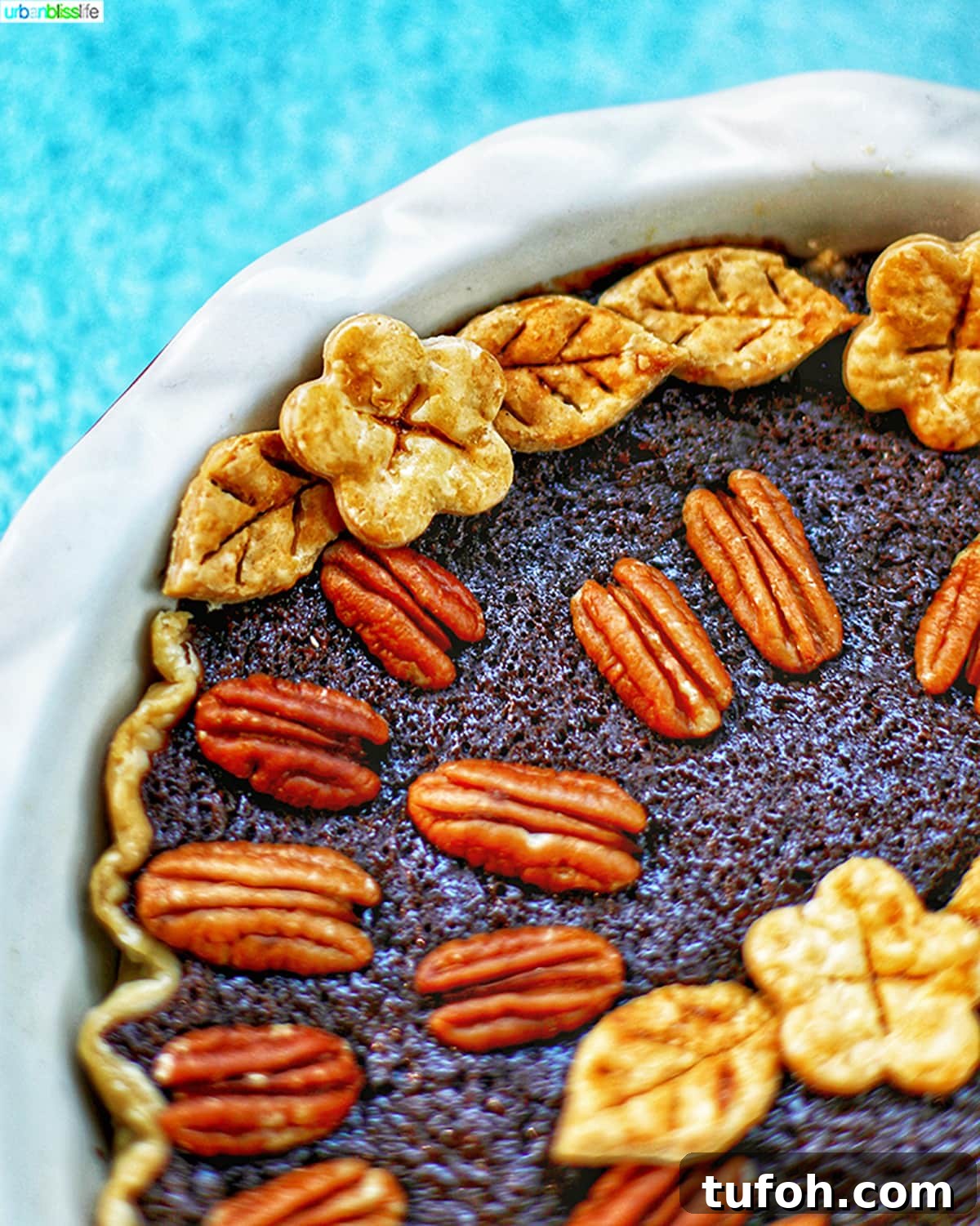 Decadent Chocolate Bourbon Pecan Pie Recipe 6 corner of Chocolate Bourbon Pecan Pie closeup of decorative pie crust leaf and flower cutouts.