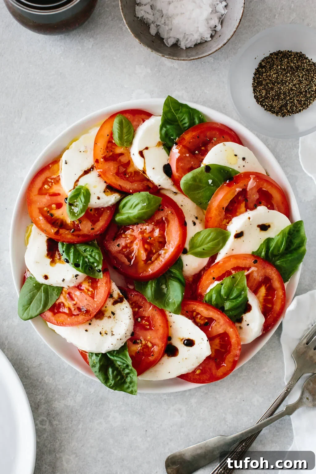 25+ Memorial Day Recipes for Grilling, Picnics & Desserts 4 Slices of tomato and mozzarella on a plate with fresh basil leaves.